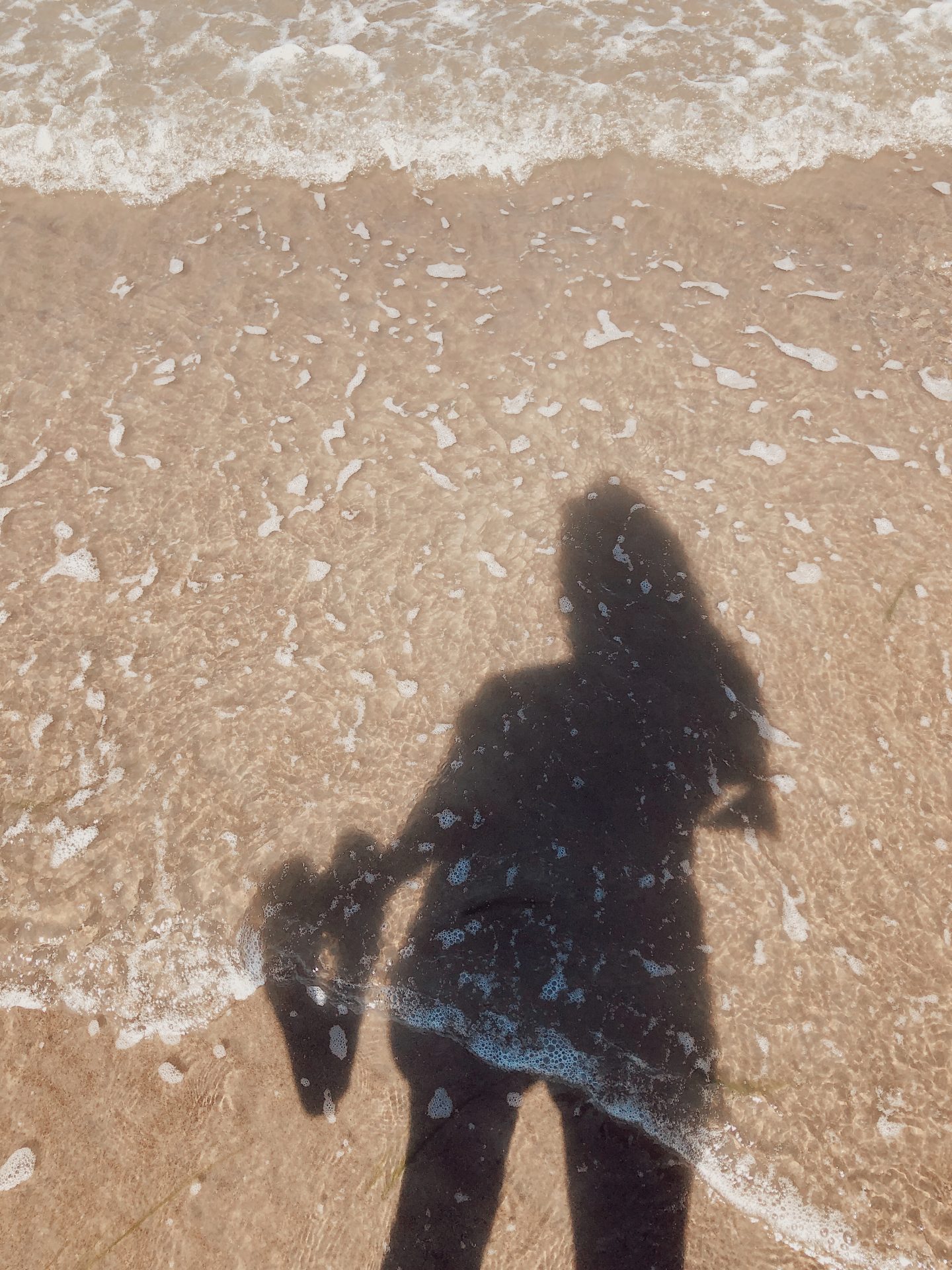 Seeing my shadow through the water on the beach