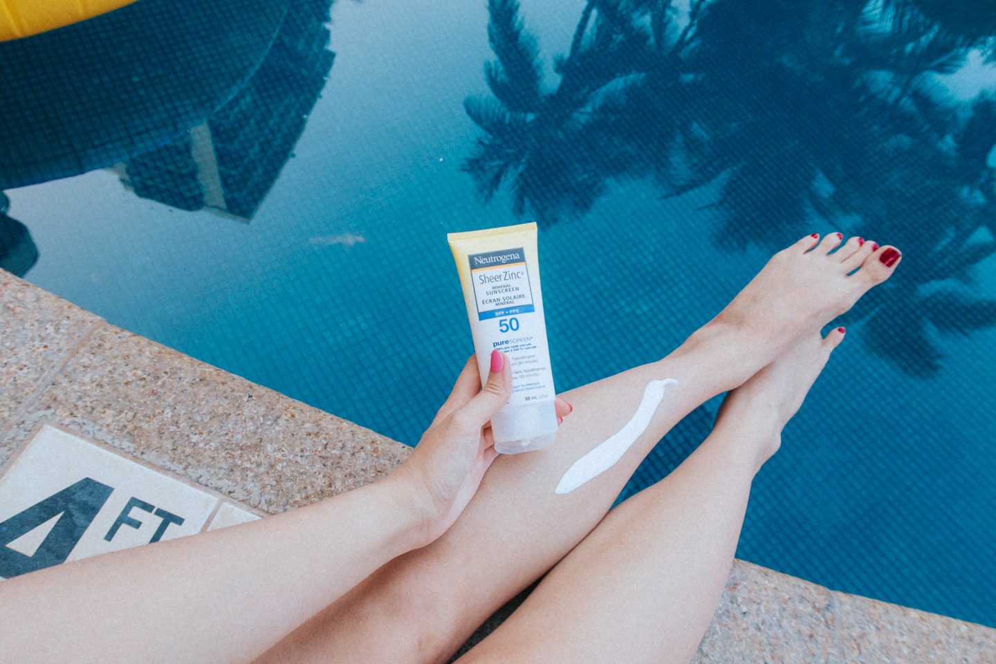 Using Neutrogena's Sheer Zinc Mineral Sunscreen poolside to protect my skin