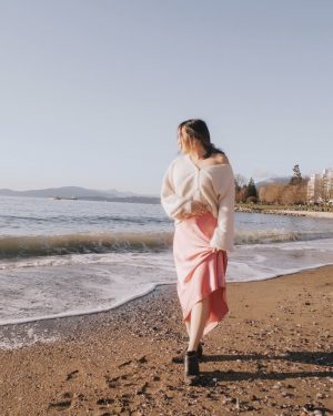 Walking along the beach in a spring outfit with pops of pink and black